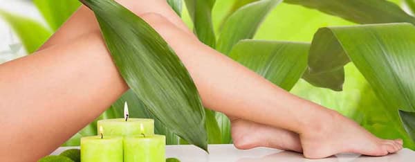 gambe di una donna con candele versi e foglie